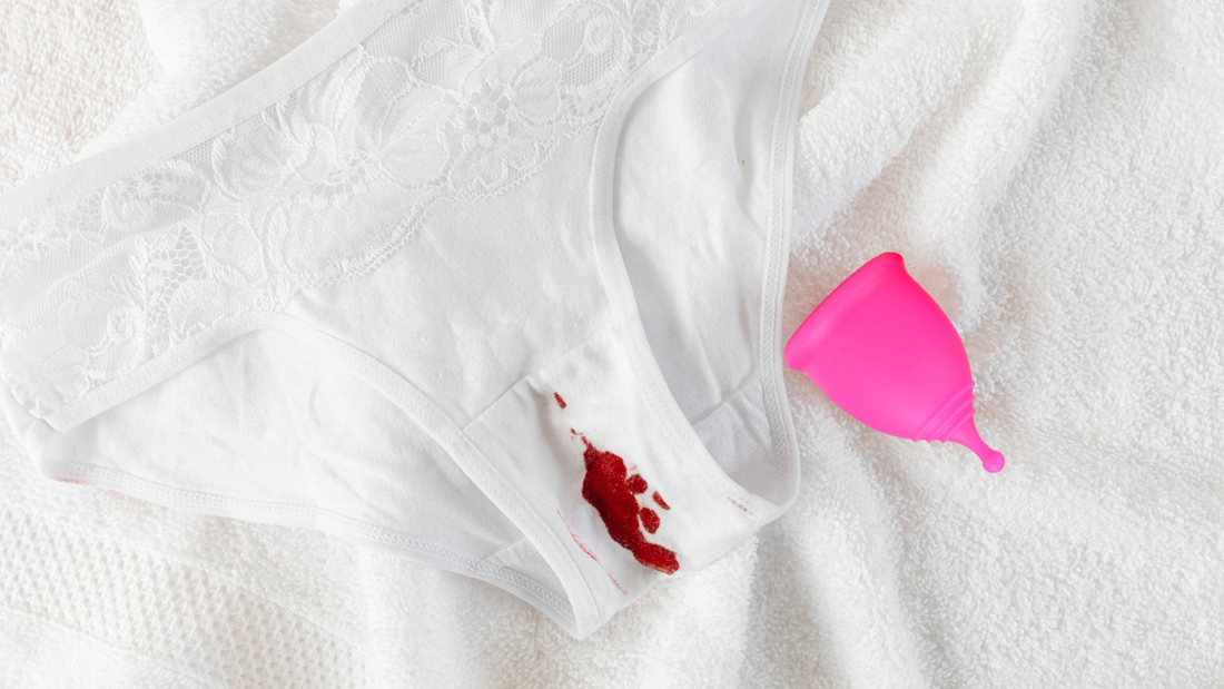 A House of Cutie menstrual cup next to a blood stained white underwear