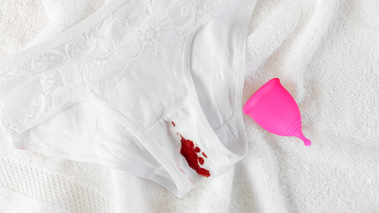 A House of Cutie menstrual cup next to a blood stained white underwear