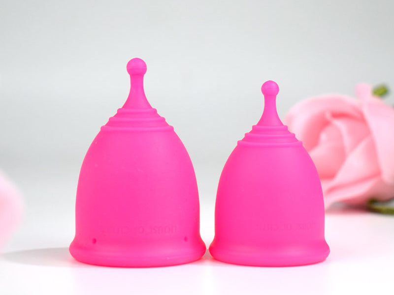 Two fuchsia coloured menstrual cup in medium and large sizes