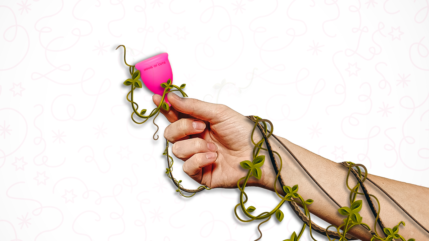 A hand with green stem and leaf around it holding a House of Cutie menstrual cup