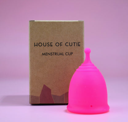 A brown eco-friendly box and a fuchsia coloured menstrual cup