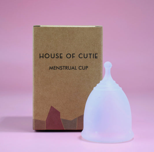 A brown eco-friendly box and a colourless white menstrual cup